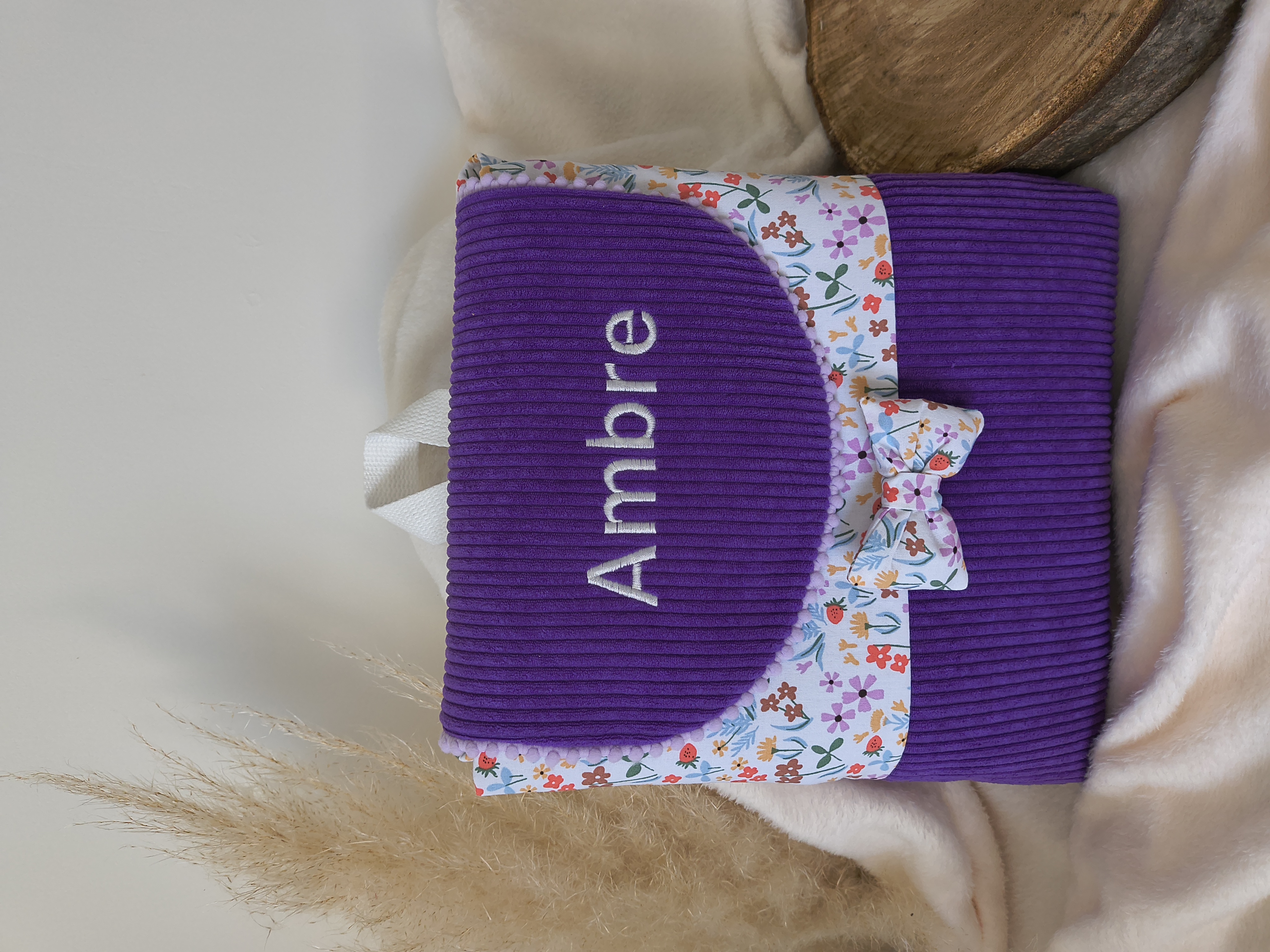 Sac à dos violet avec nœud fleuri et prénom brodé