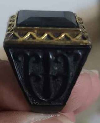 Metal ring with black stone and golden frame
