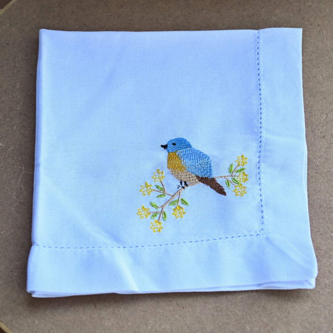 Guardanapo de tecido branco com bordado de pássaro azul
