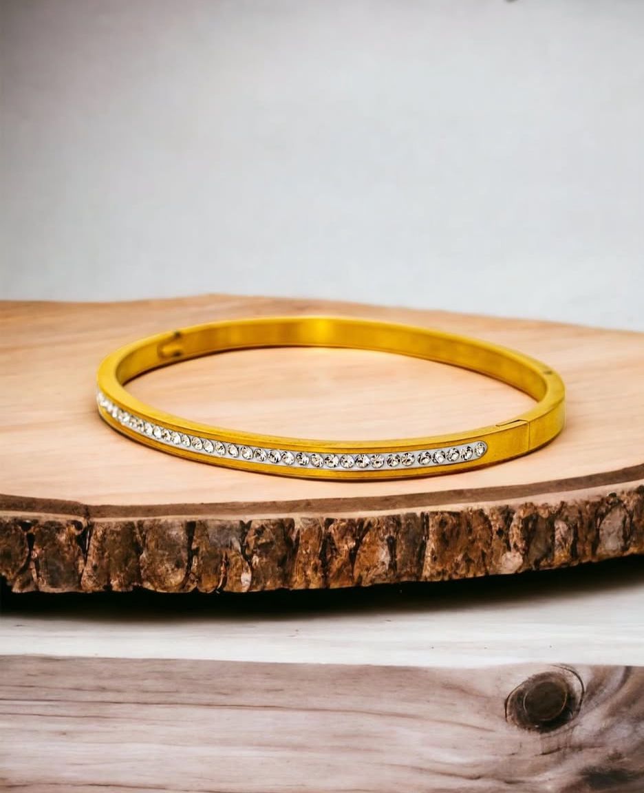 Bracelete de aço, com Banho dourado e pedra zircônia.