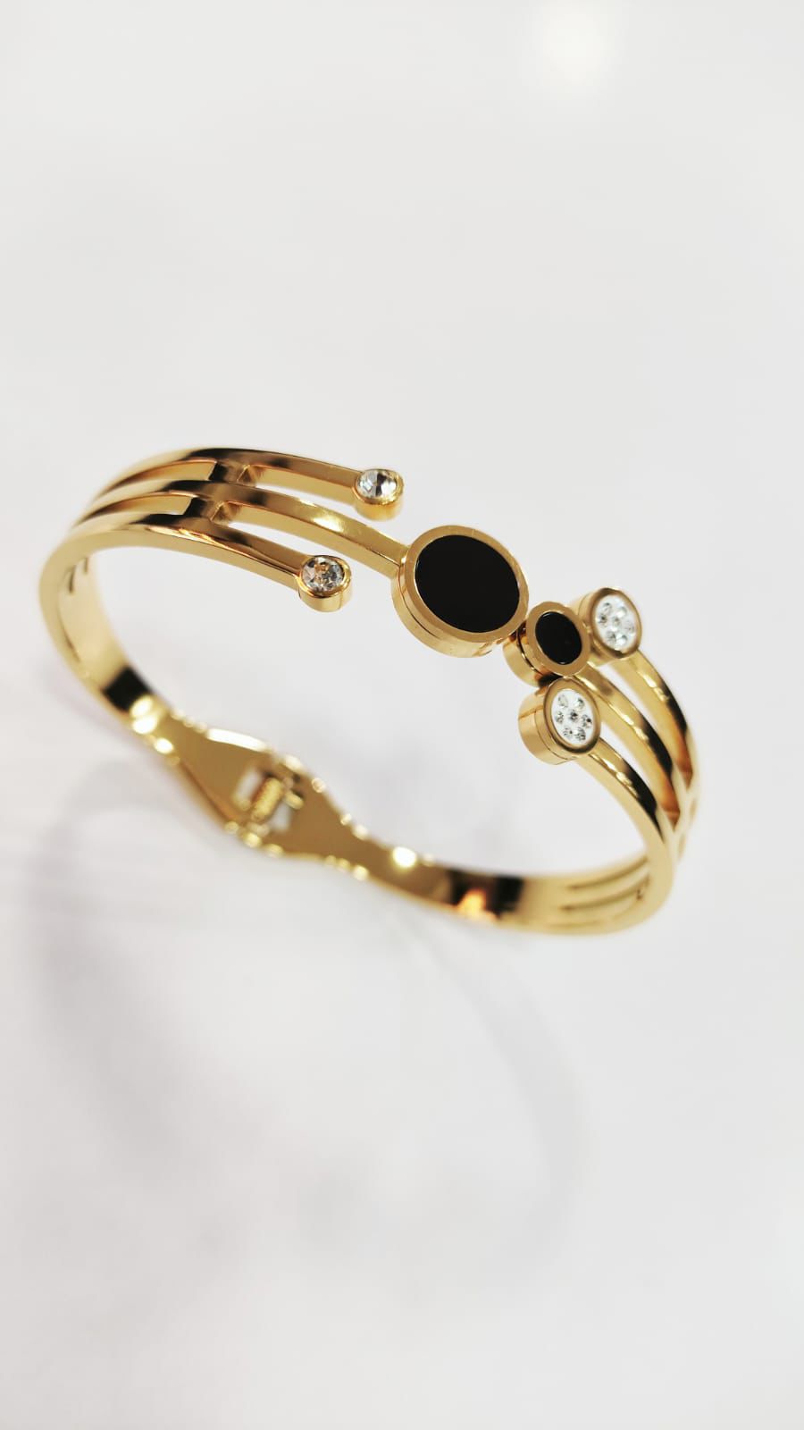 Bracelete de aço com banho dourado e pedra zircônia.