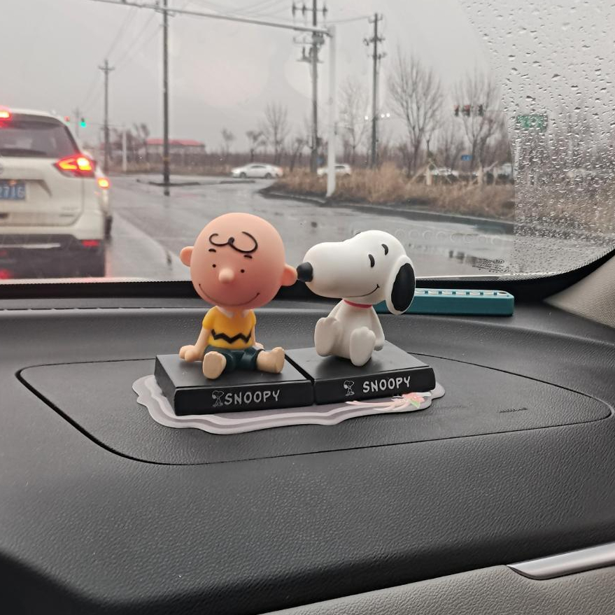 Snoopy and Charlie Brown shaking head figurines phone holder