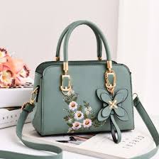 Bolso de mano verde con flores bordadas