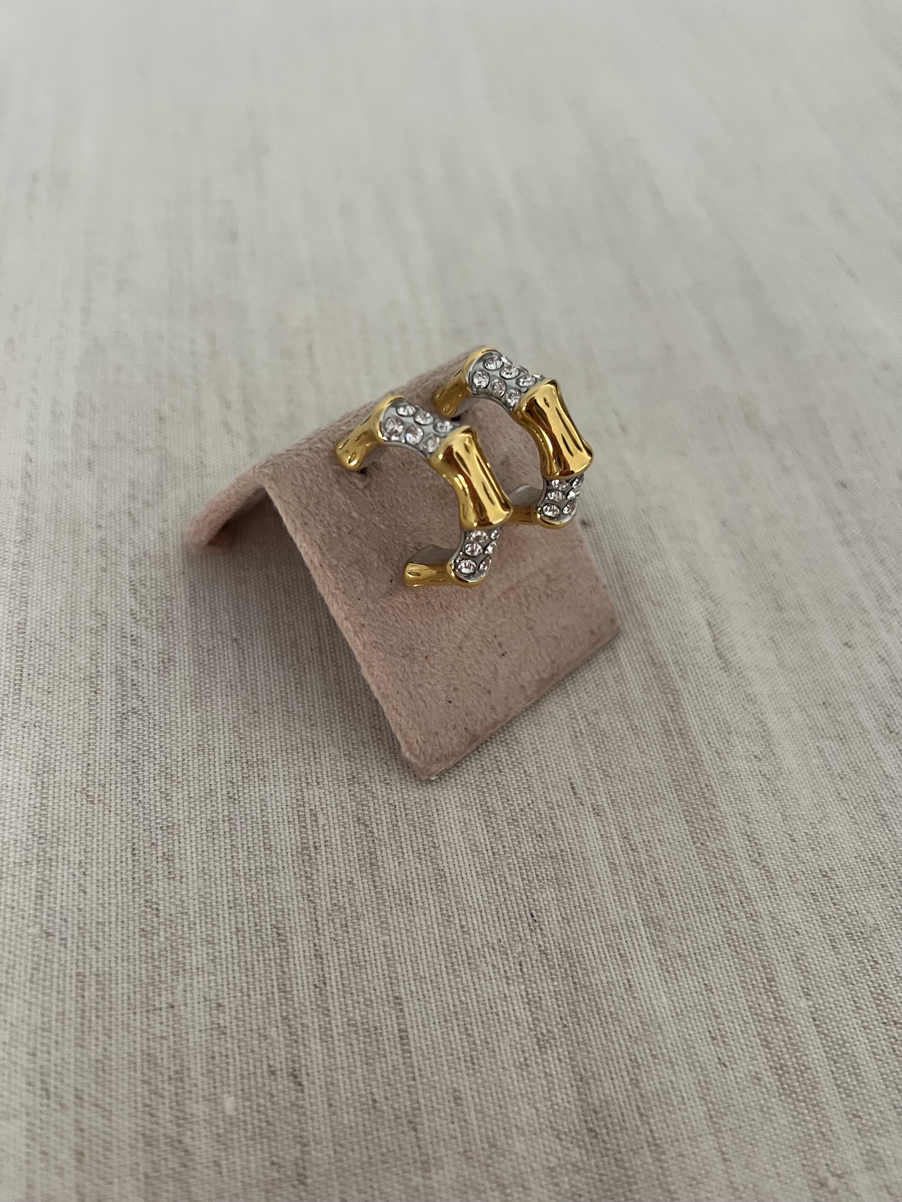 Brinco dourado com pedras brilhantes