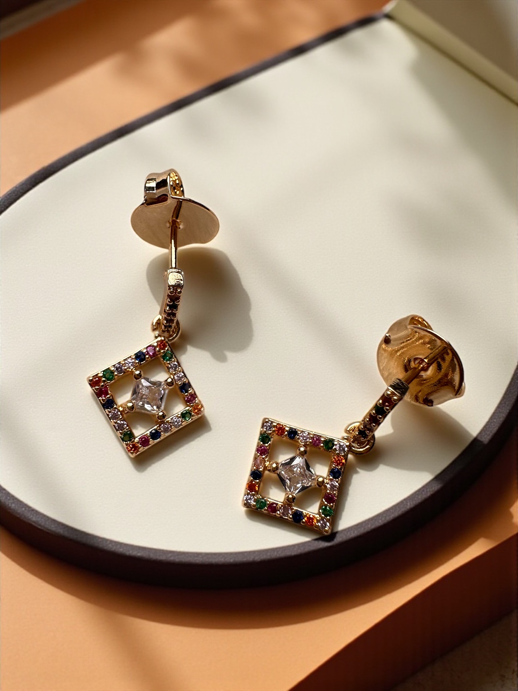 Brincos dourados com pedras coloridas