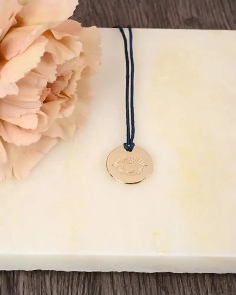 Médaille œil porte-bonheur dorée - élégante amulette de protection