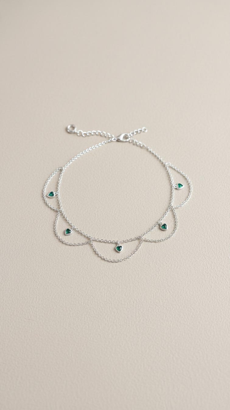 Tornozeleira de prata com pedras em formato de corações verdes