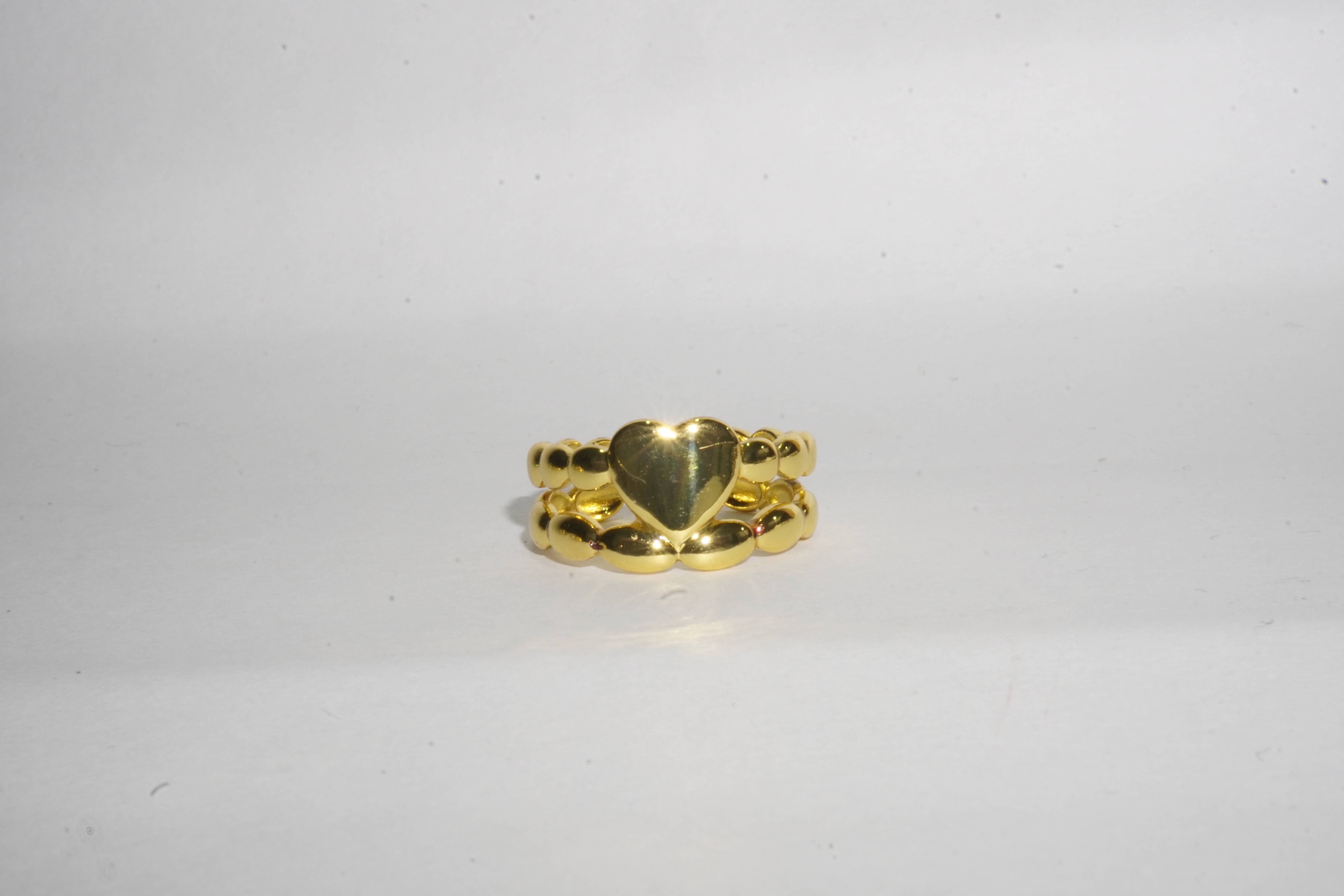 Anillo dorado con corazón y cuentas