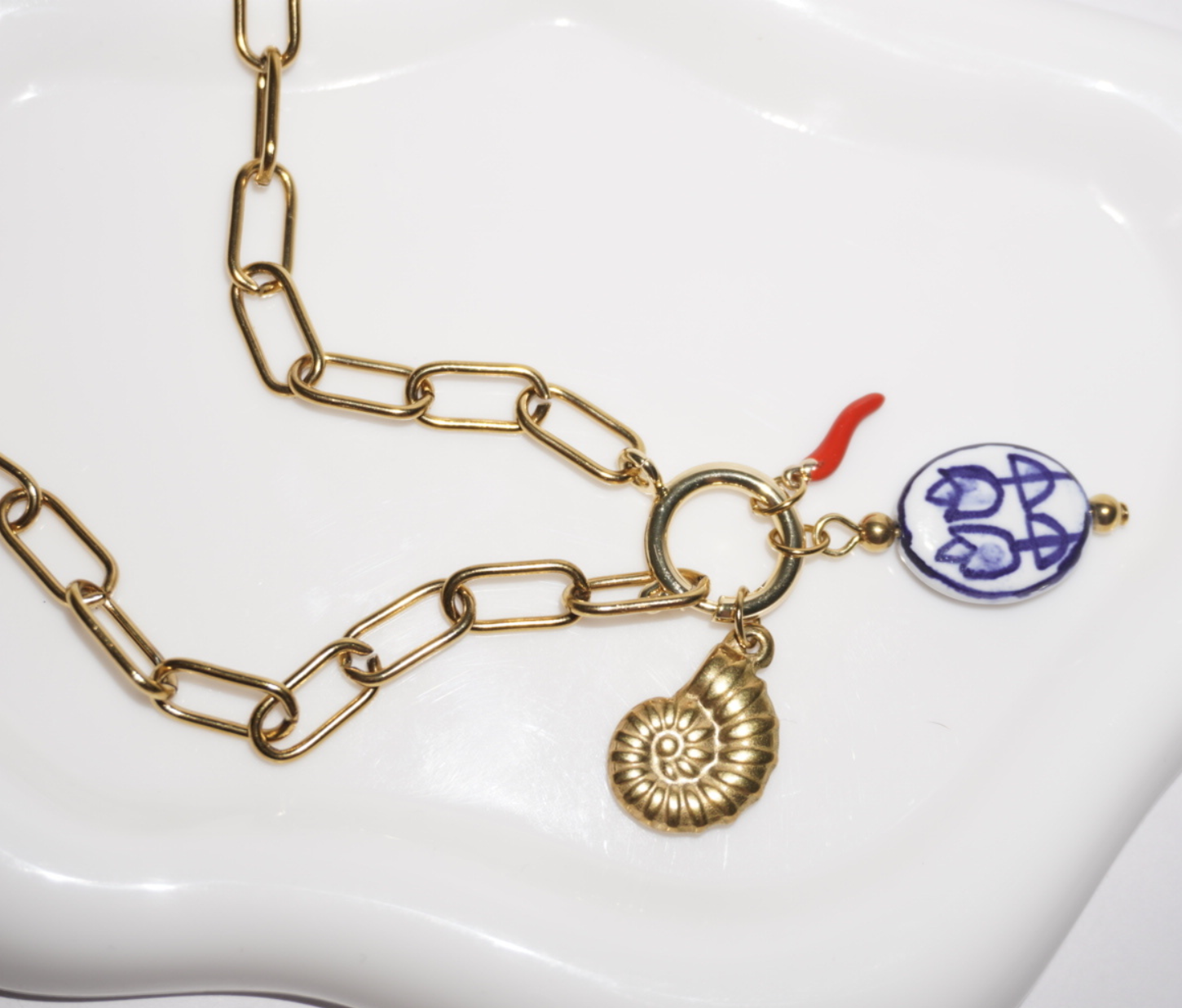 Collar dorado con dijes de concha, chile y talavera