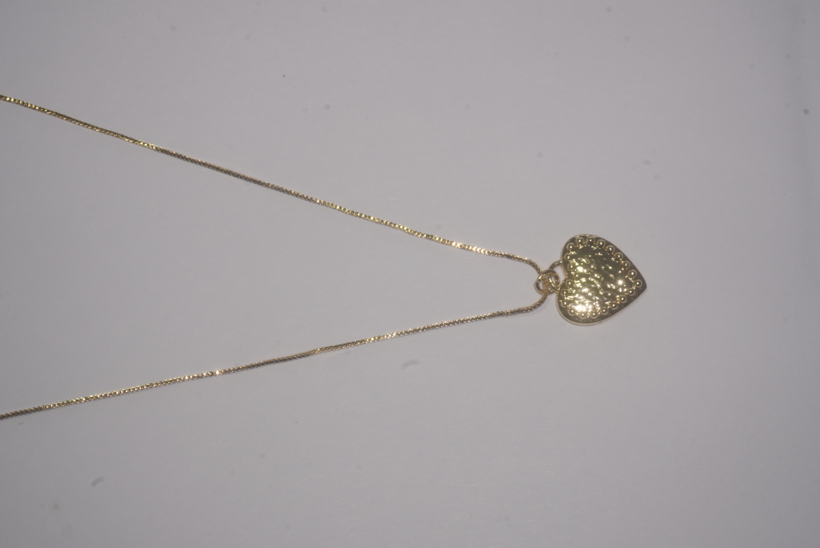 Collar dorado con corazón con textura