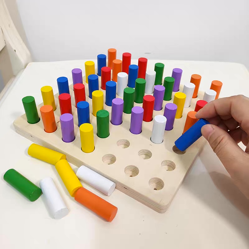 Tablero de motricidad con cilindros de colores.