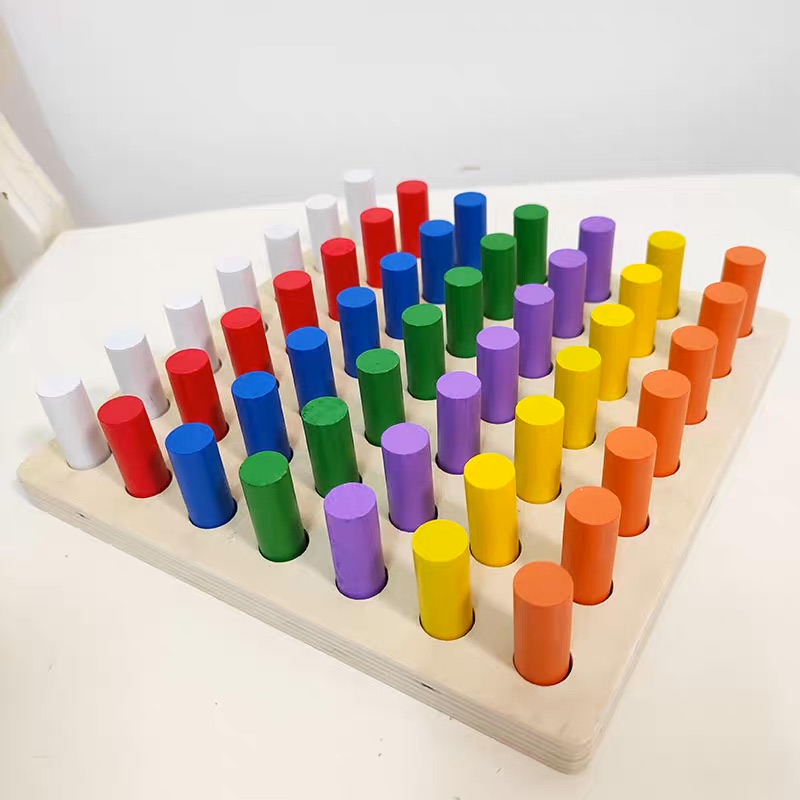 Tablero de motricidad con cilindros de colores.