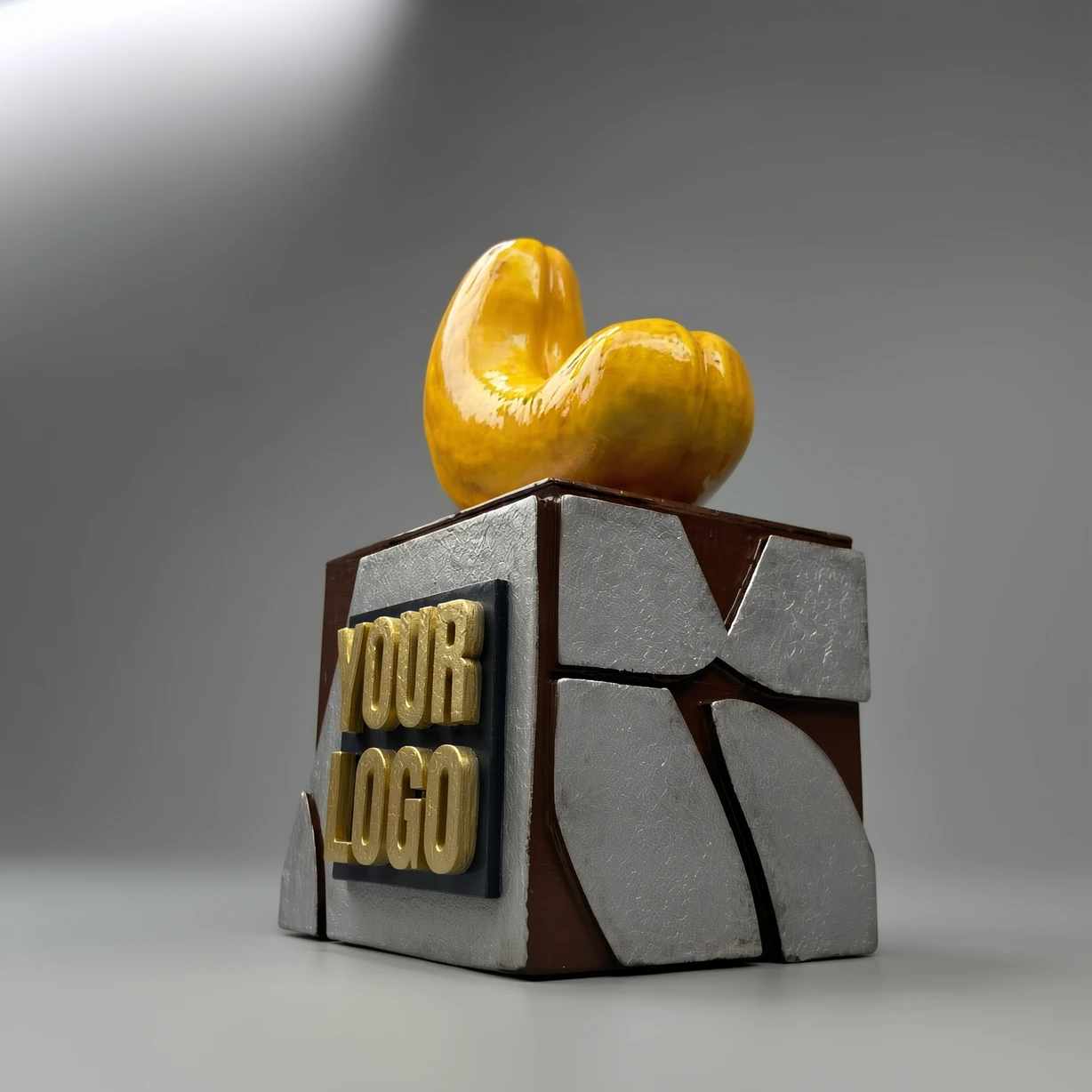مجسم فني: حبة كاجو لامعة على قاعدة مكعبة