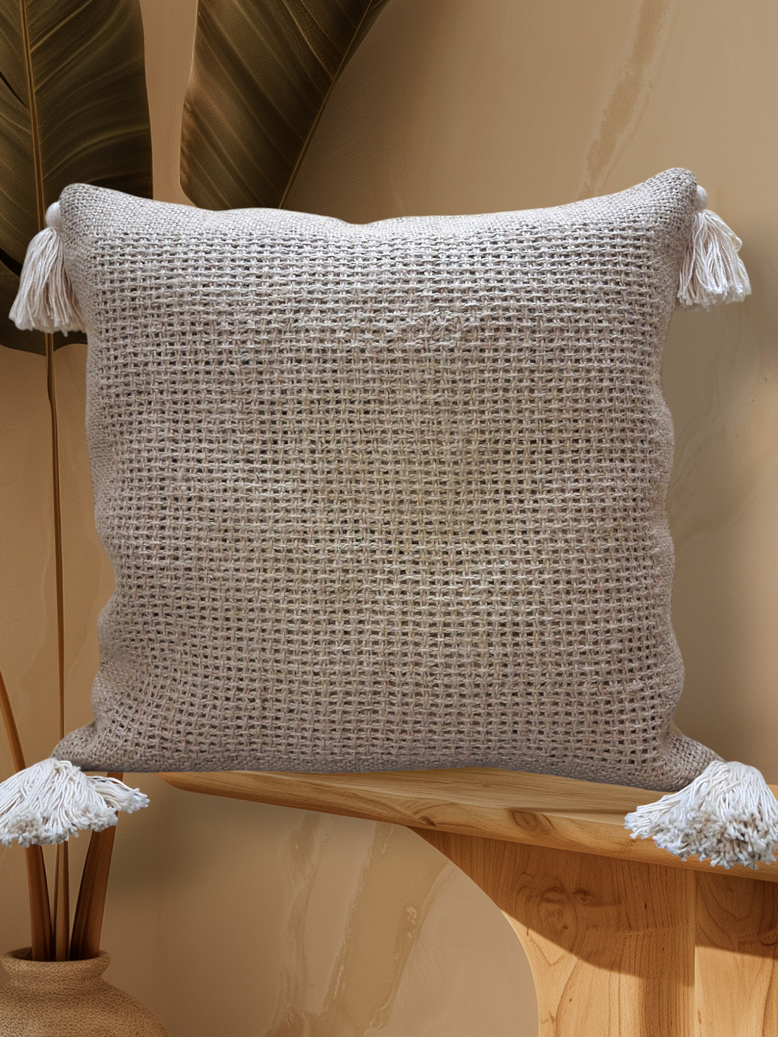 Cojín tejido con borlas