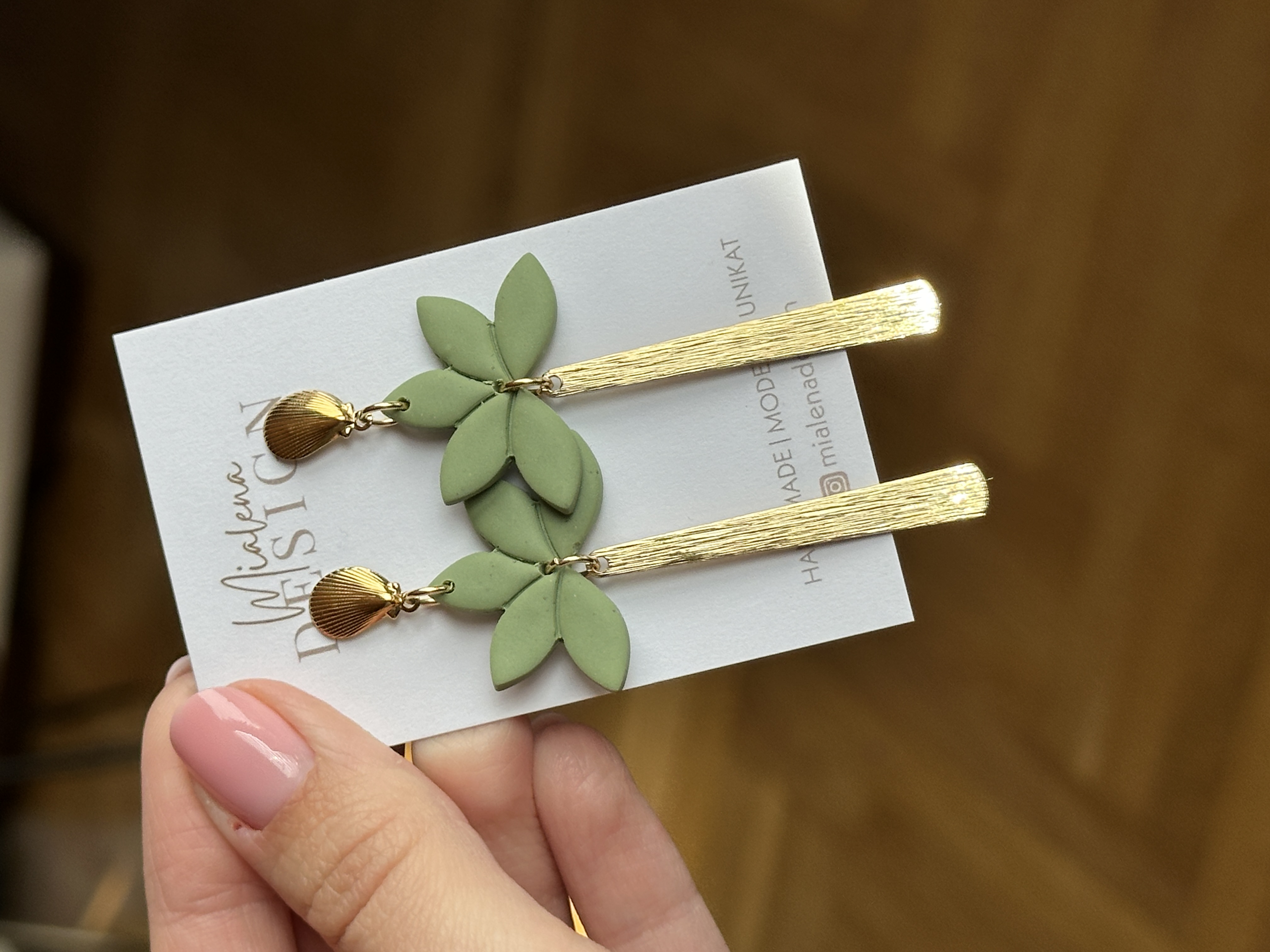 Goldene Ohrringe mit grünen Blättern