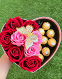 Caja de regalo en forma de corazón con rosas y chocolates