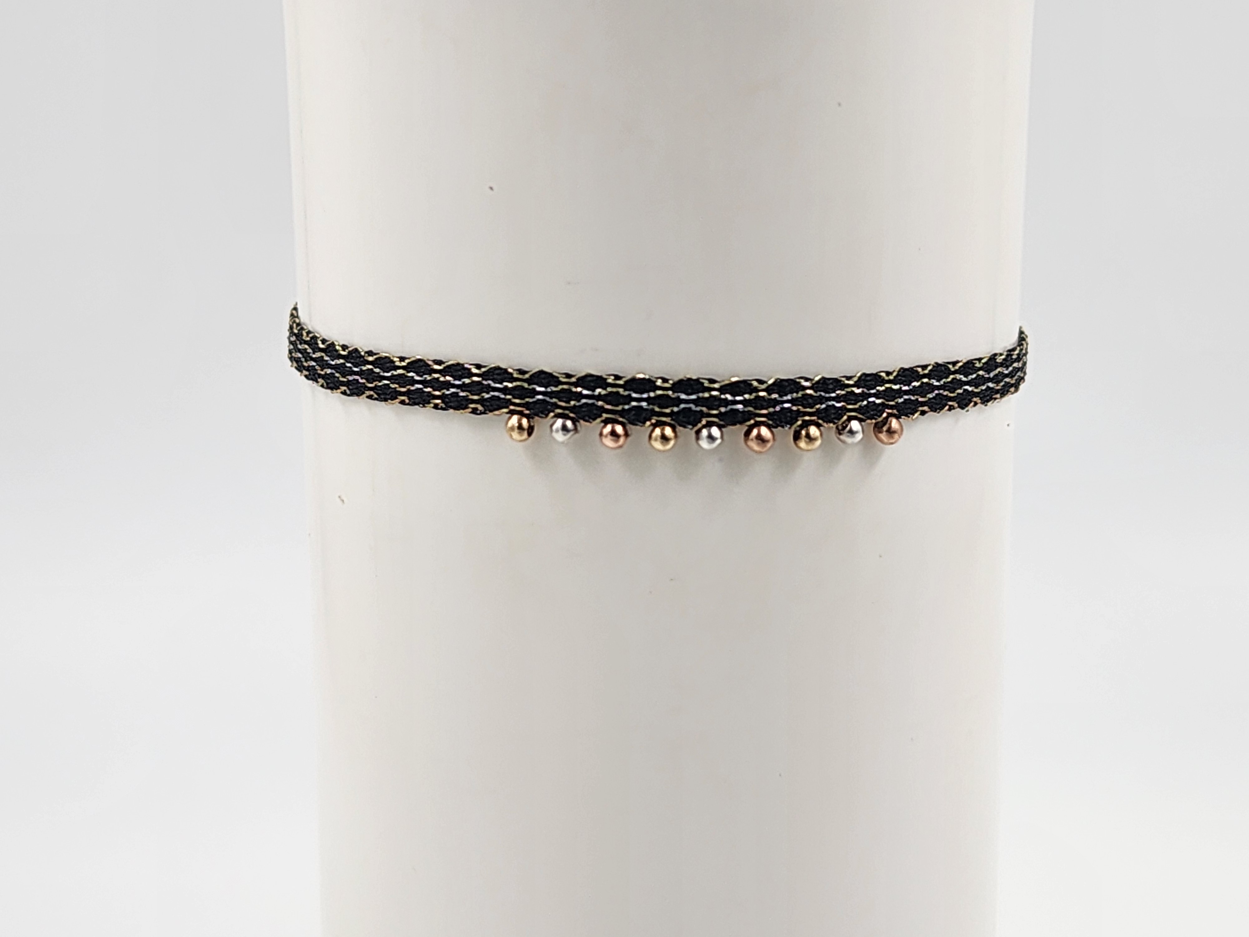 Pulsera de hilo negro con cuentas metálicas