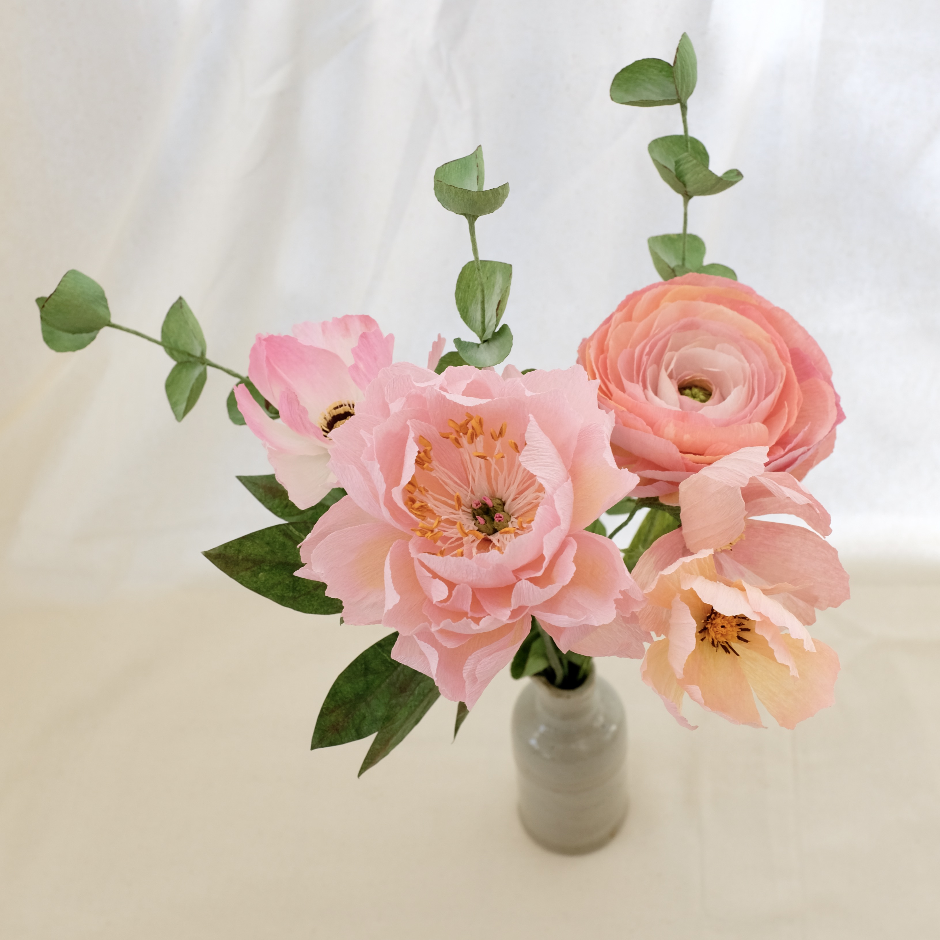 Bouquet de fleurs en papier : pivoine rose tendre, renoncule rose, trois cosmos roses et trois brins eucalyptus