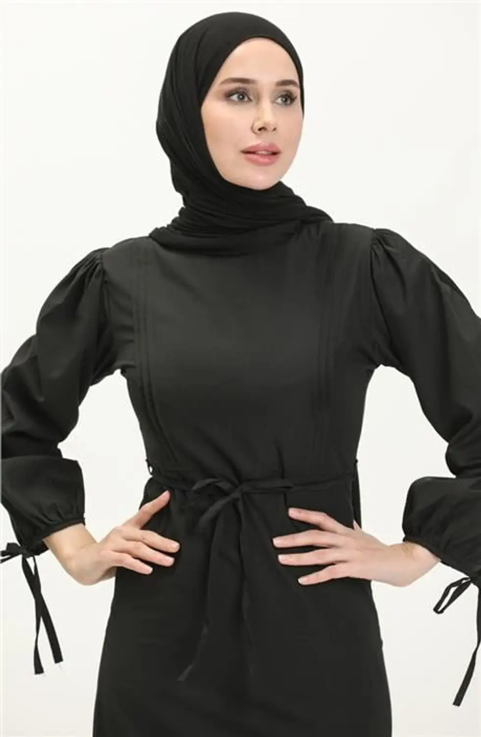 فستان أسود طويل بتصميم "نيرفور" وتفاصيل عند الخصر