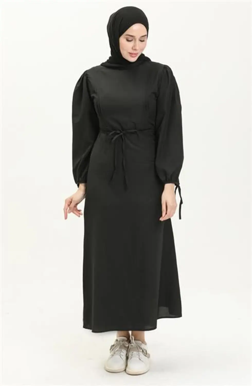 فستان أسود طويل بتصميم "نيرفور" وتفاصيل عند الخصر