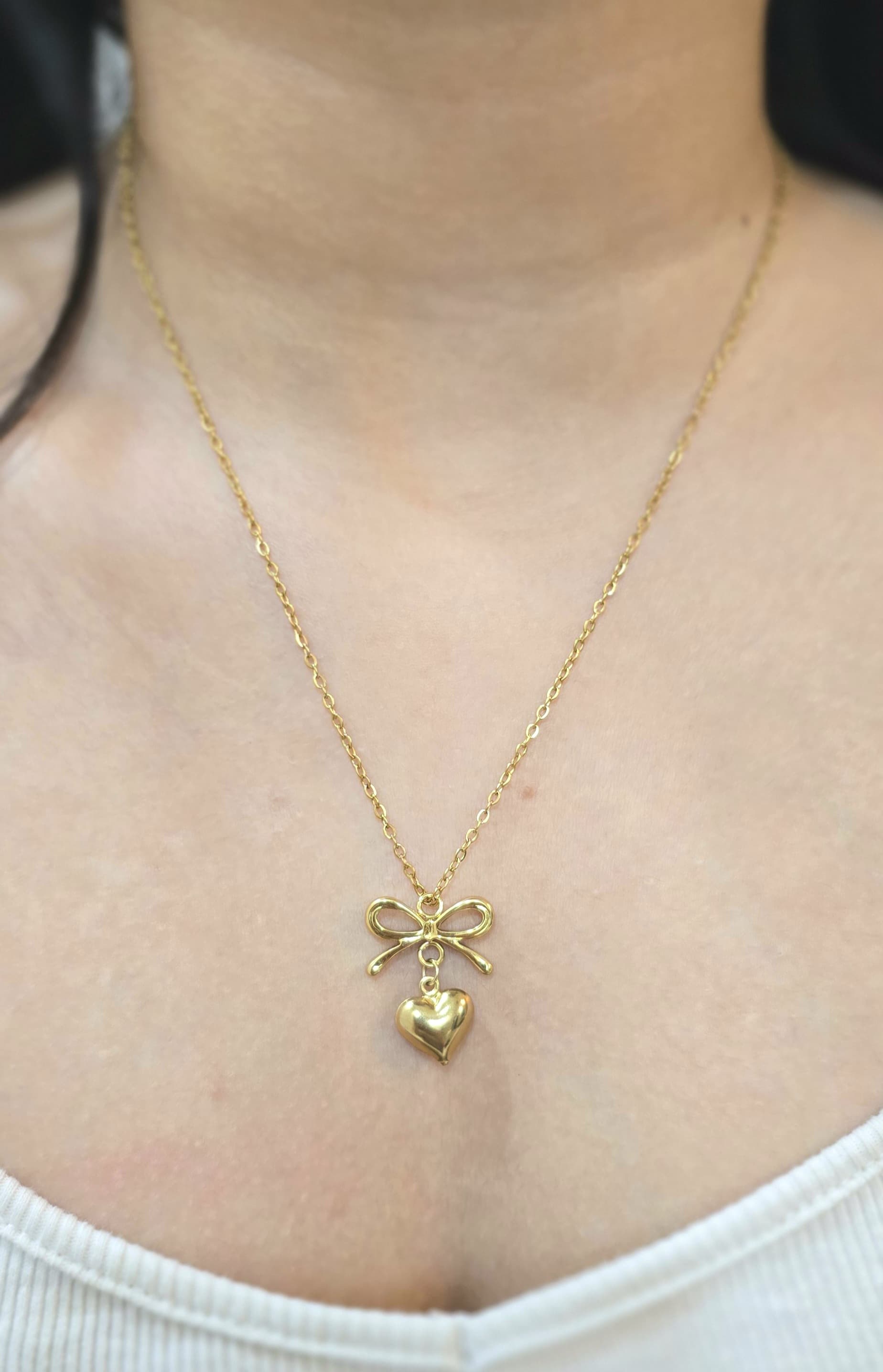 Gold bow and heart pendant necklace