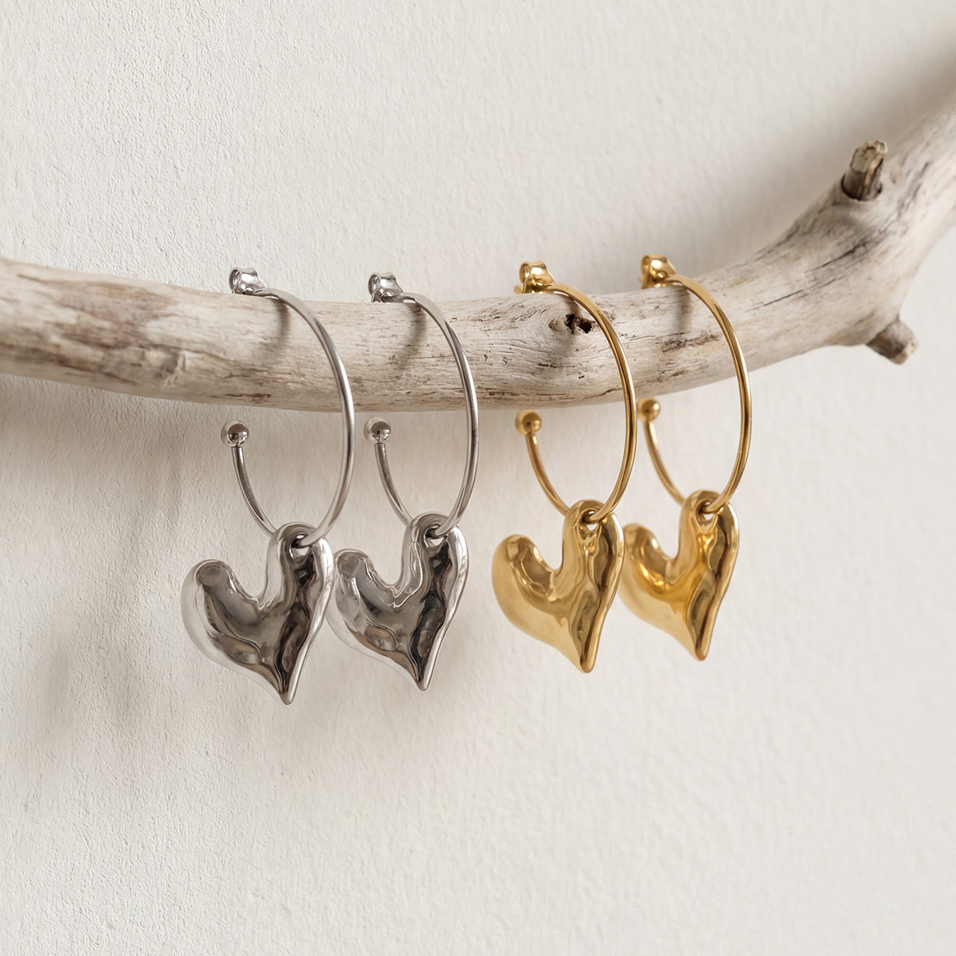 Stainless steel stud earrings with heart-shaped pendants. 502051