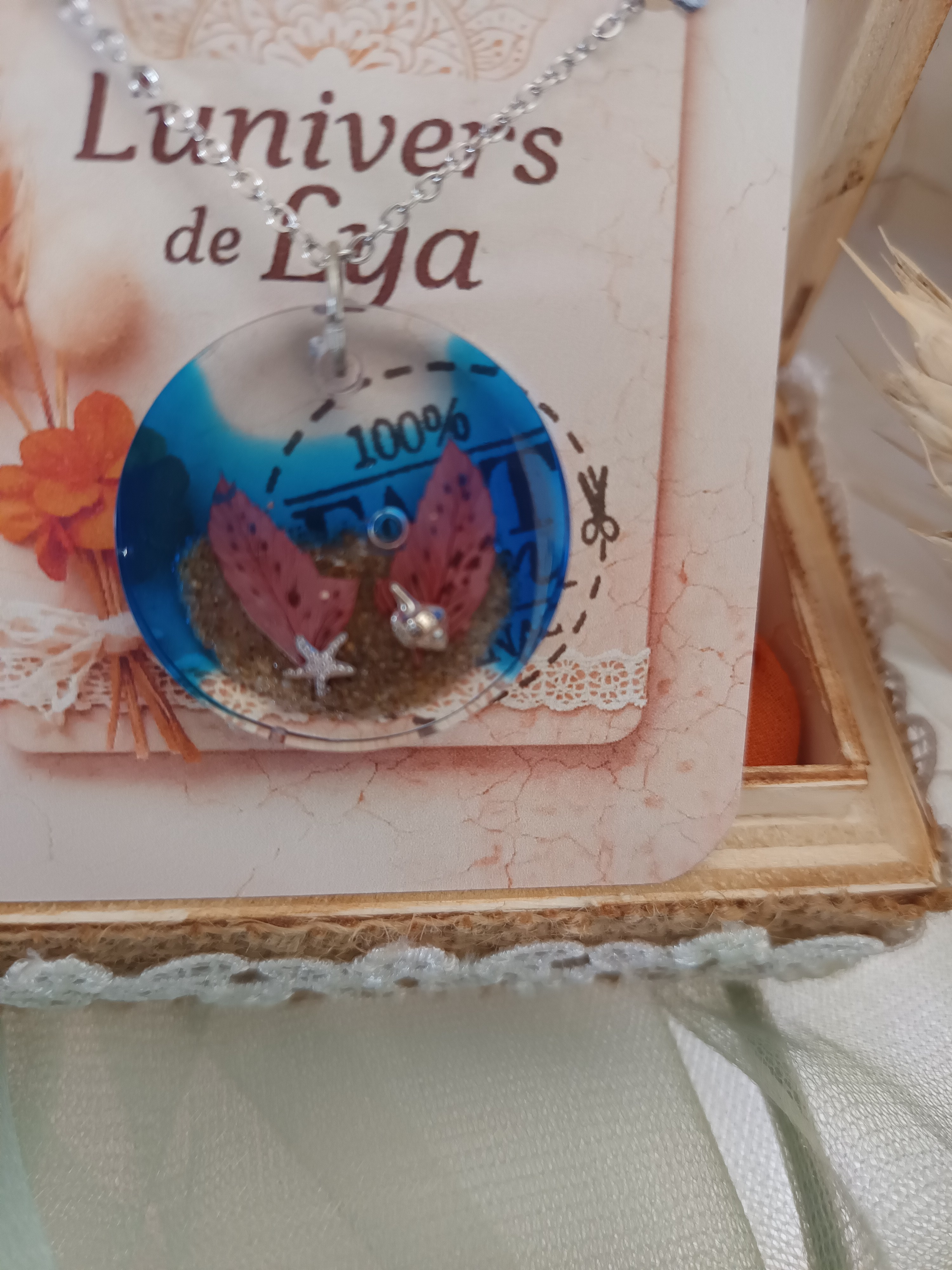 Collier artisanal en résine bleue profonde avec fleurs séchées – Pendentif rond bohème inspiration océan