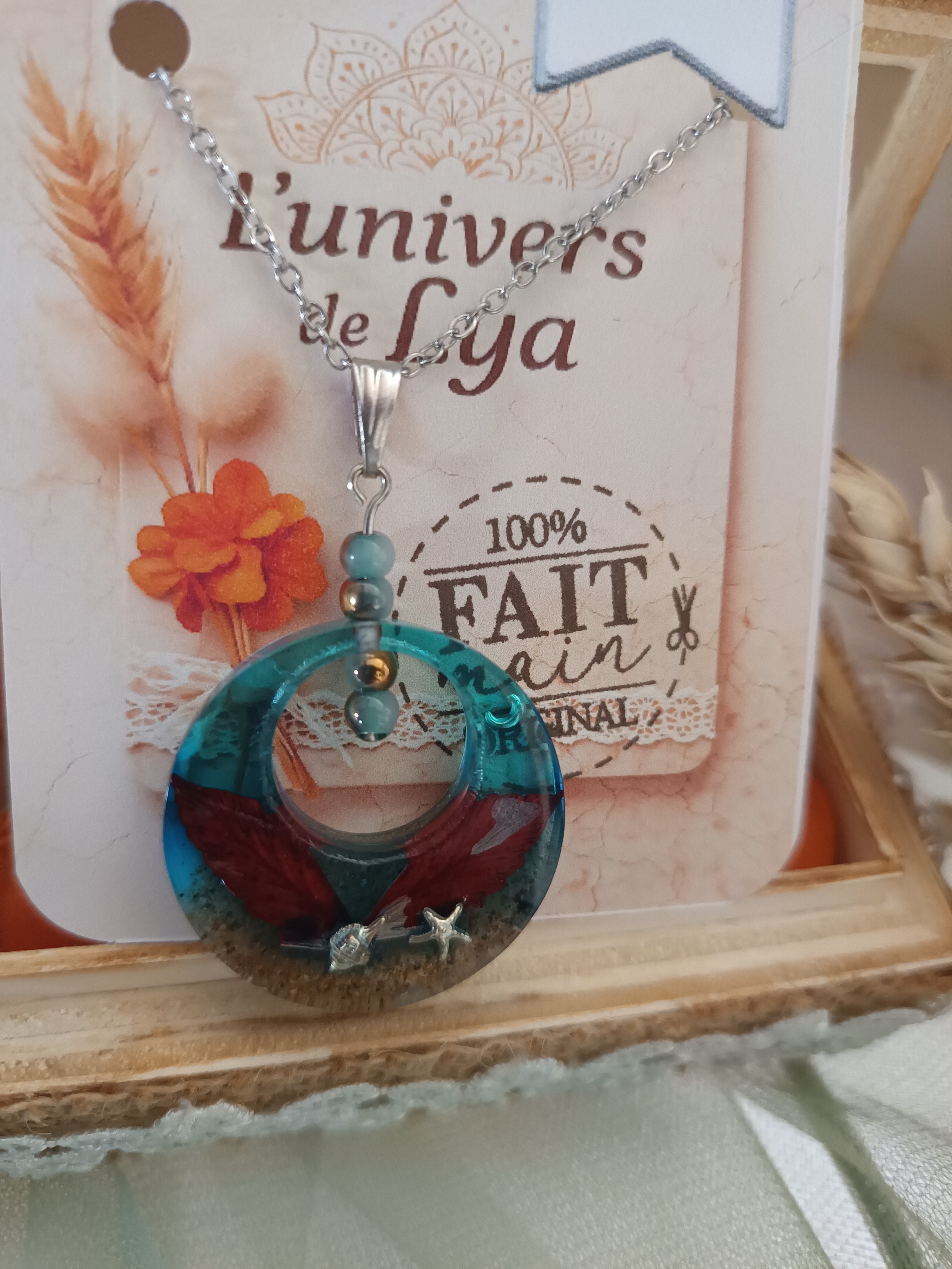 Collier artisanal en résine turquoise avec fleurs séchées – Pendentif rond inspiration mer et nature