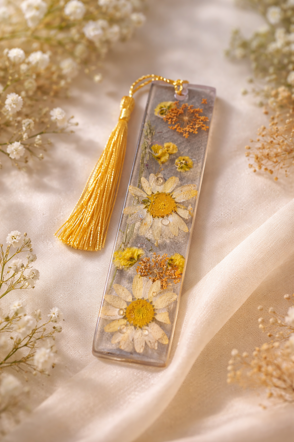 Marque-page artisanal en résine avec fleurs séchées jaunes et pompon doré