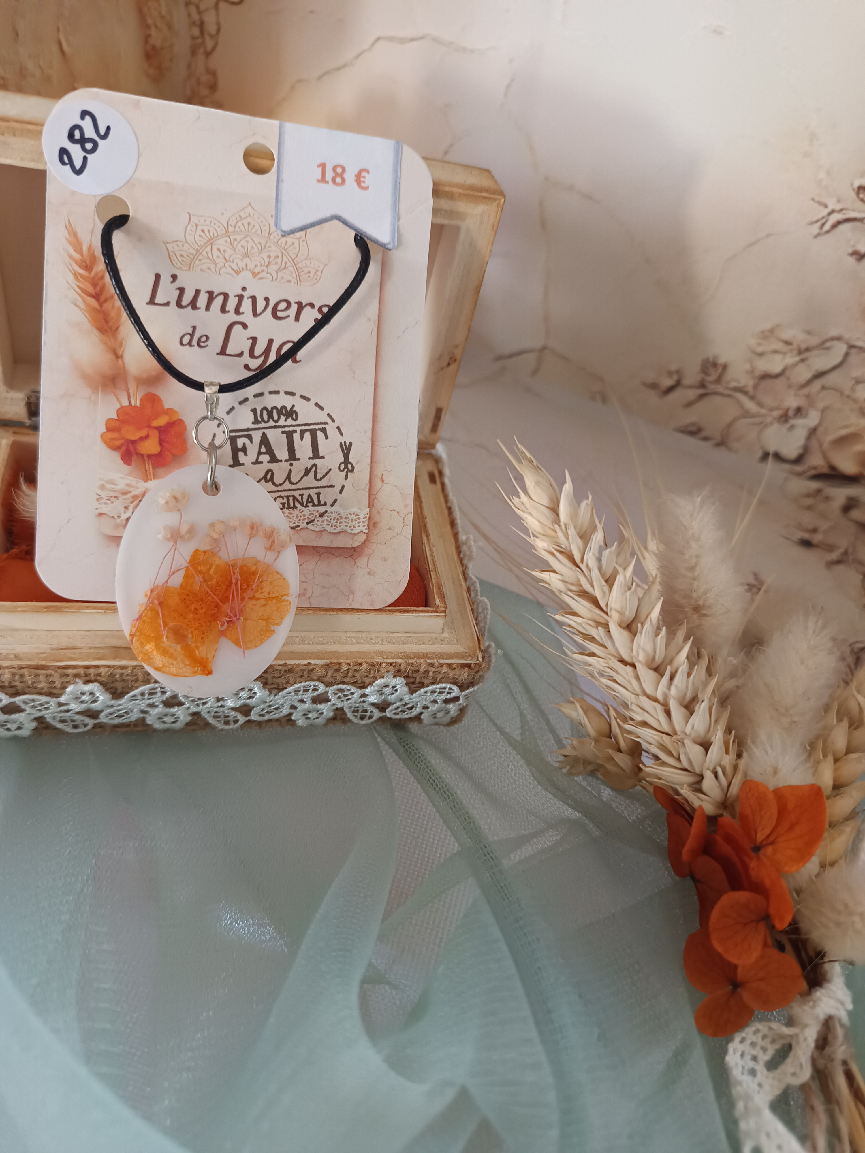 Collier artisanal en résine blanche avec fleurs orangées séchées – Pendentif ovale bohème naturel