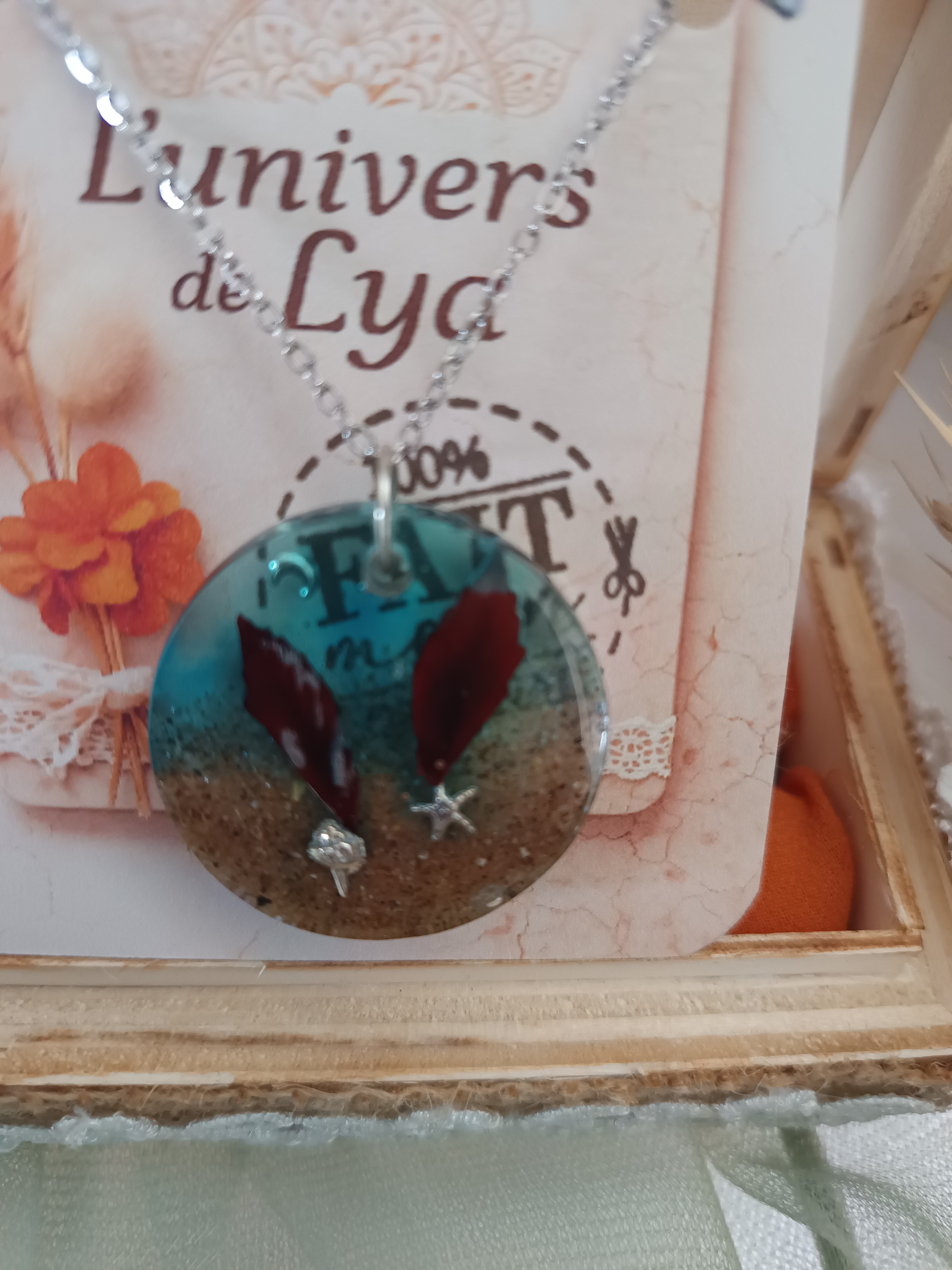 Collier artisanal en résine bleue profonde avec fleurs séchées – Pendentif rond bohème inspiration océan