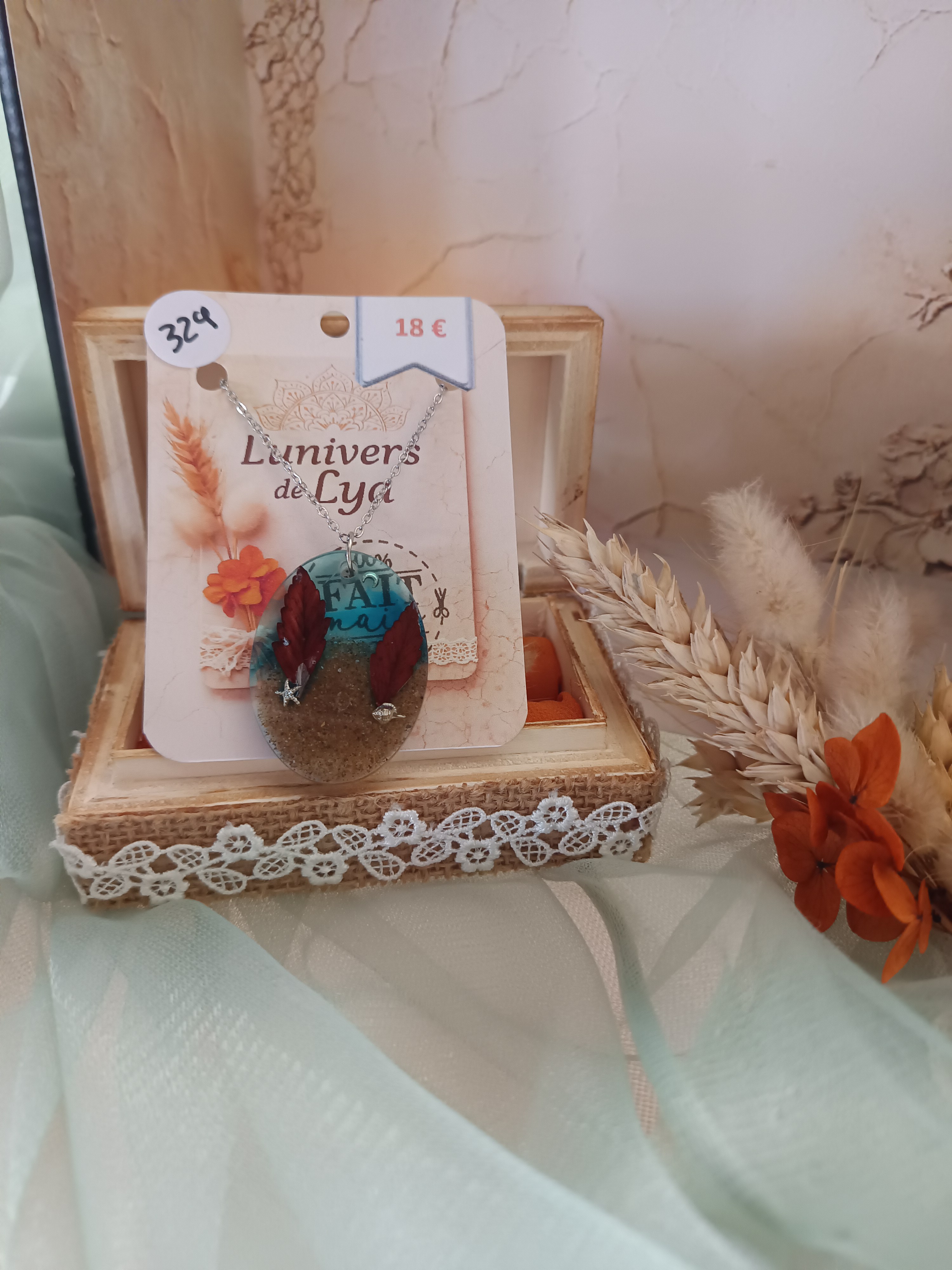 Collier artisanal en résine bleue avec fleurs séchées – Pendentif ovale bohème inspiration plage