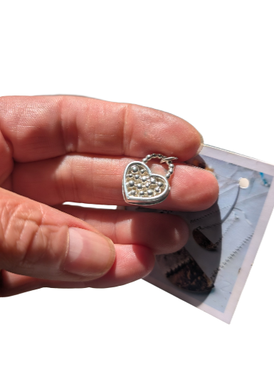 Sterling silver pendant, heart shaped with detail.