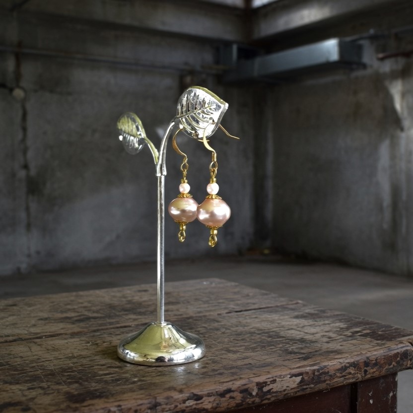 Pink glass pearl earrings with reflective card on engagement