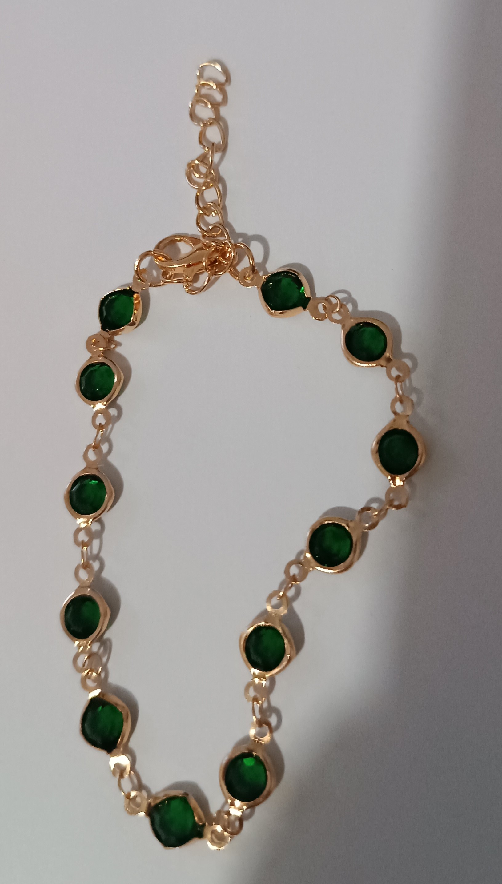 Bracelet doré avec pierres vertes