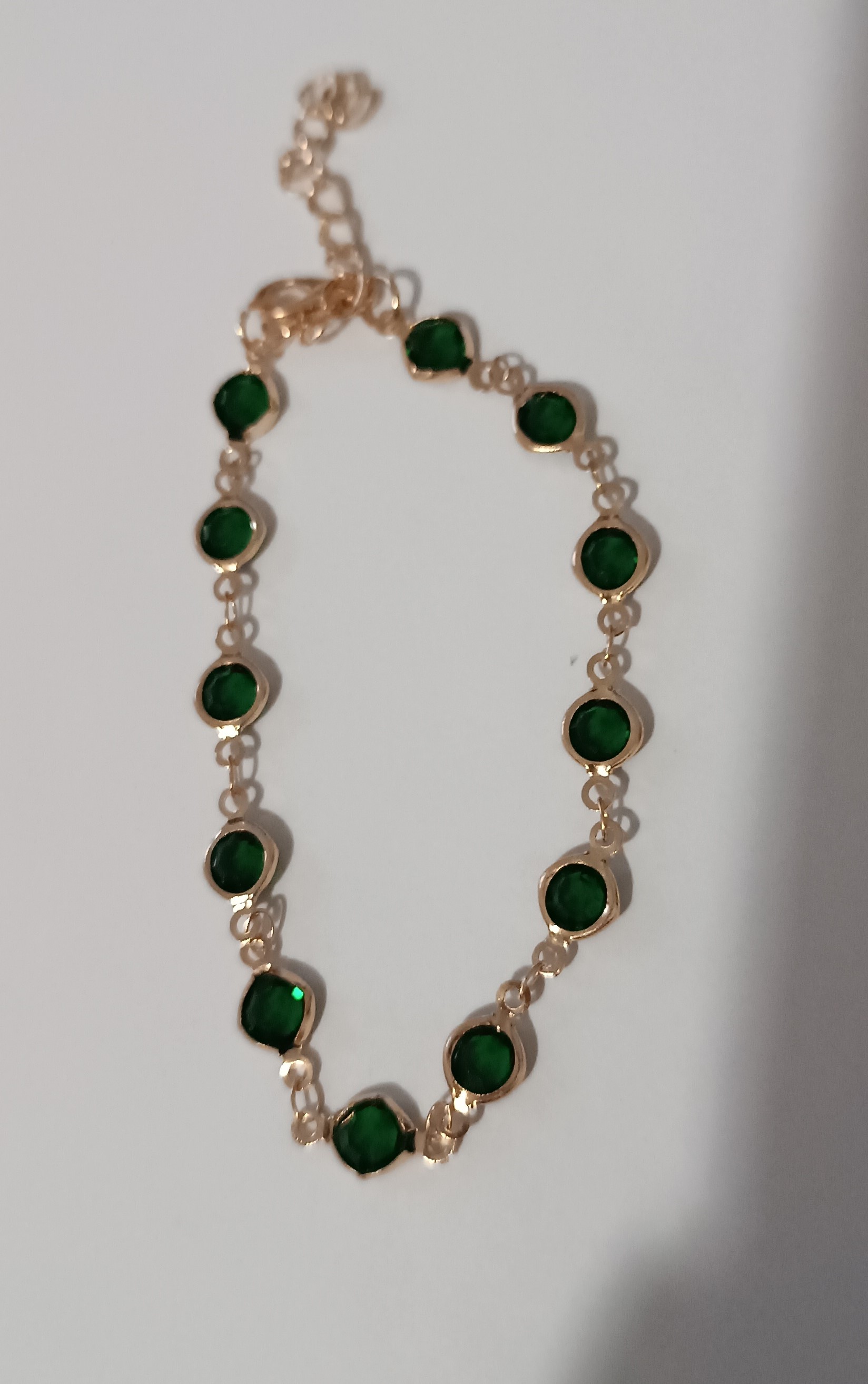 Bracelet doré avec pierres vertes