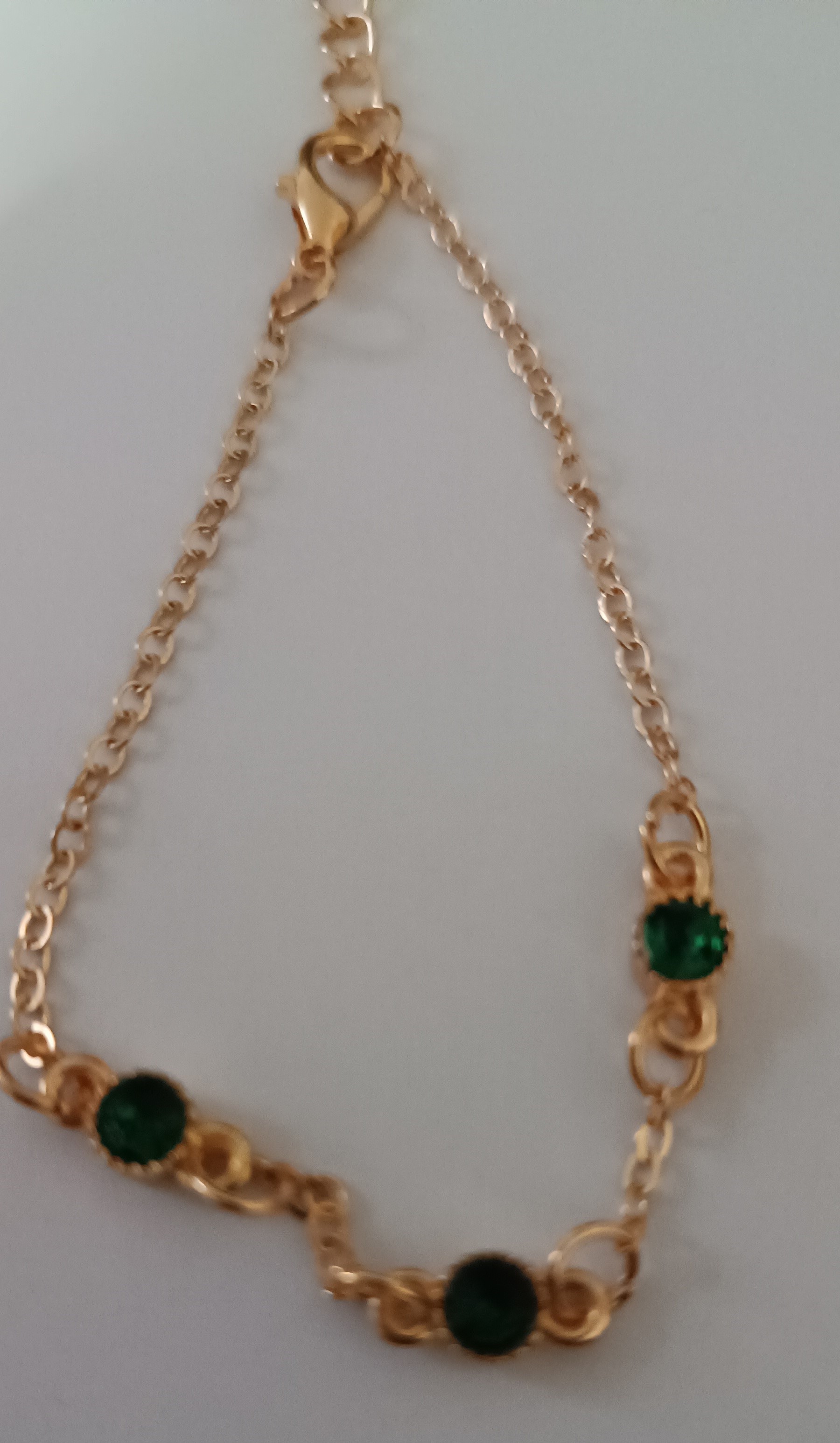 Bracelet doré avec pierres vertes