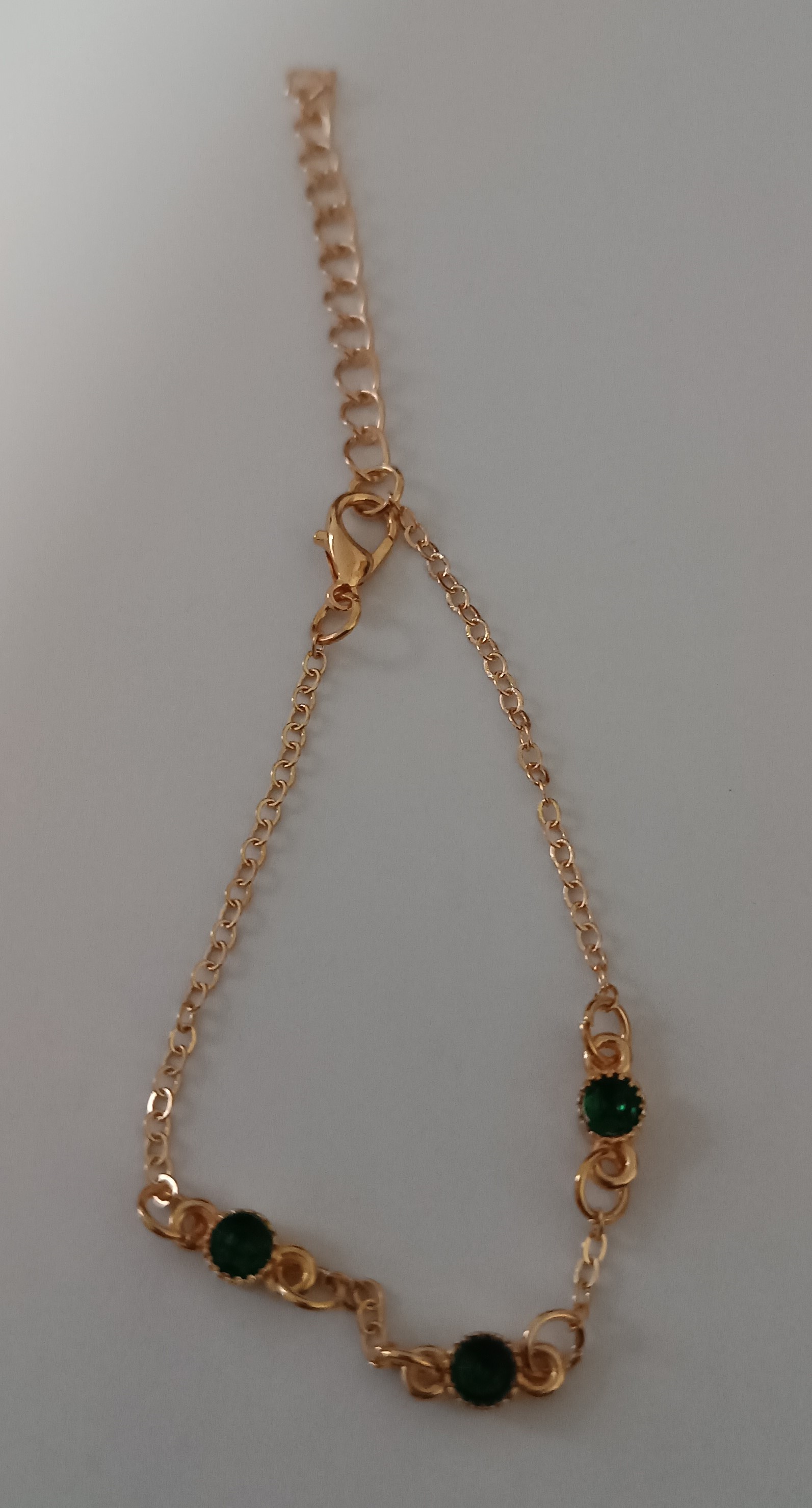 Bracelet doré avec pierres vertes