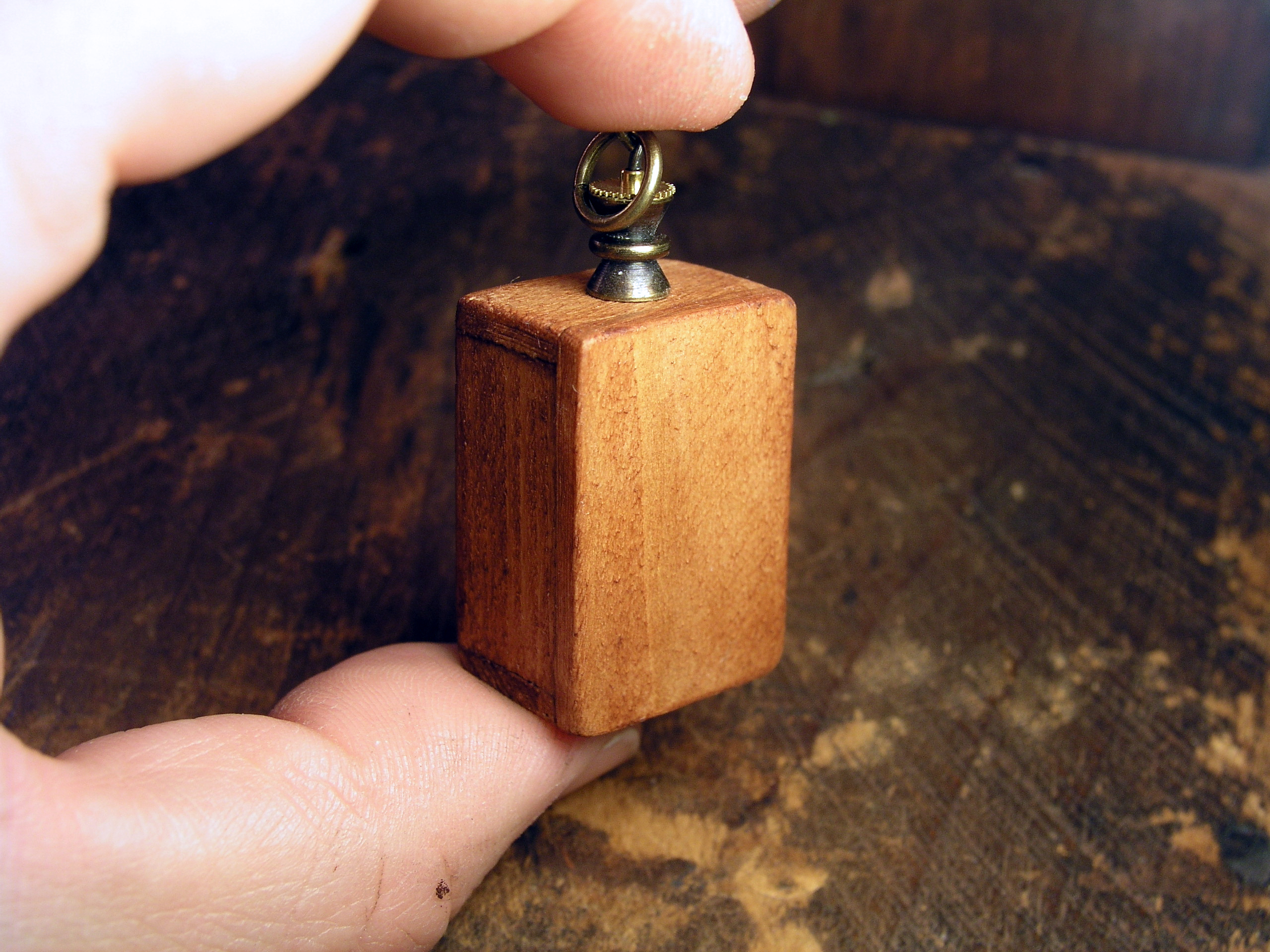Miniature World Pendant. A boy and birl are holding hands while looking out a window at the night sky.
