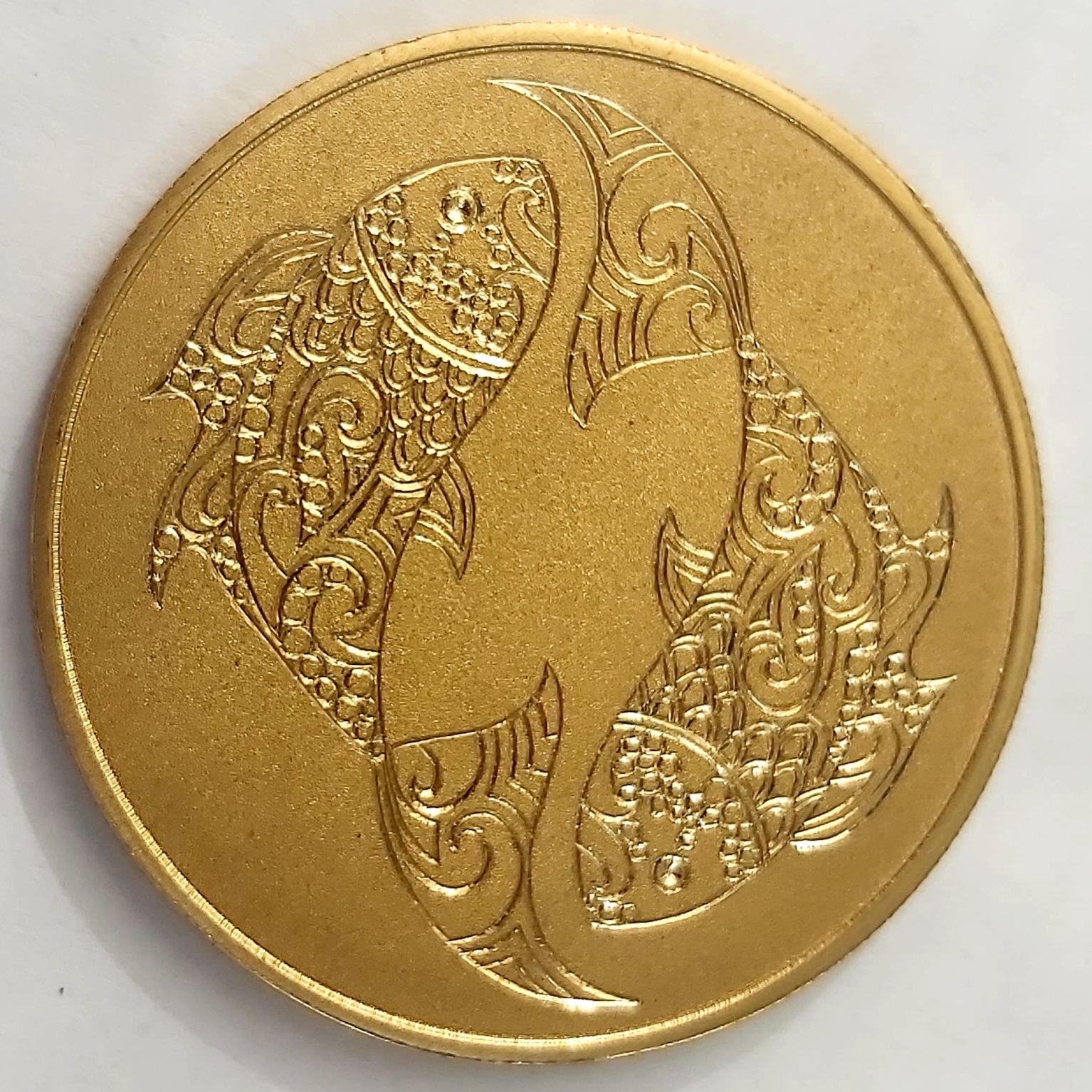 Moneda de latón dorado con 