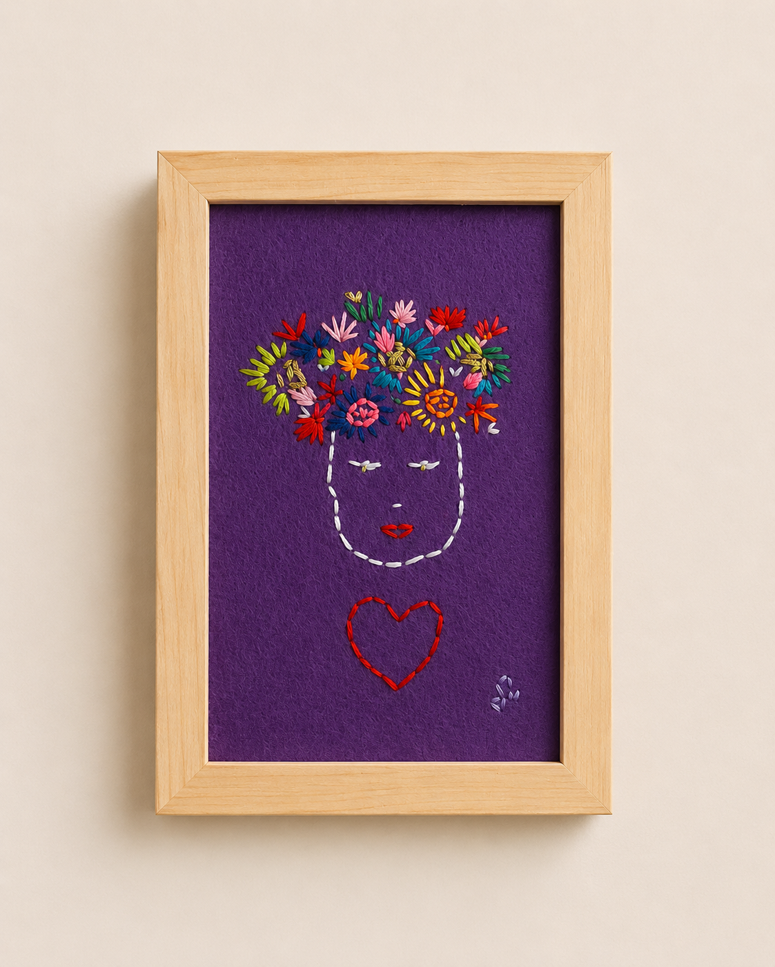 Broderie visage fleuri encadrée