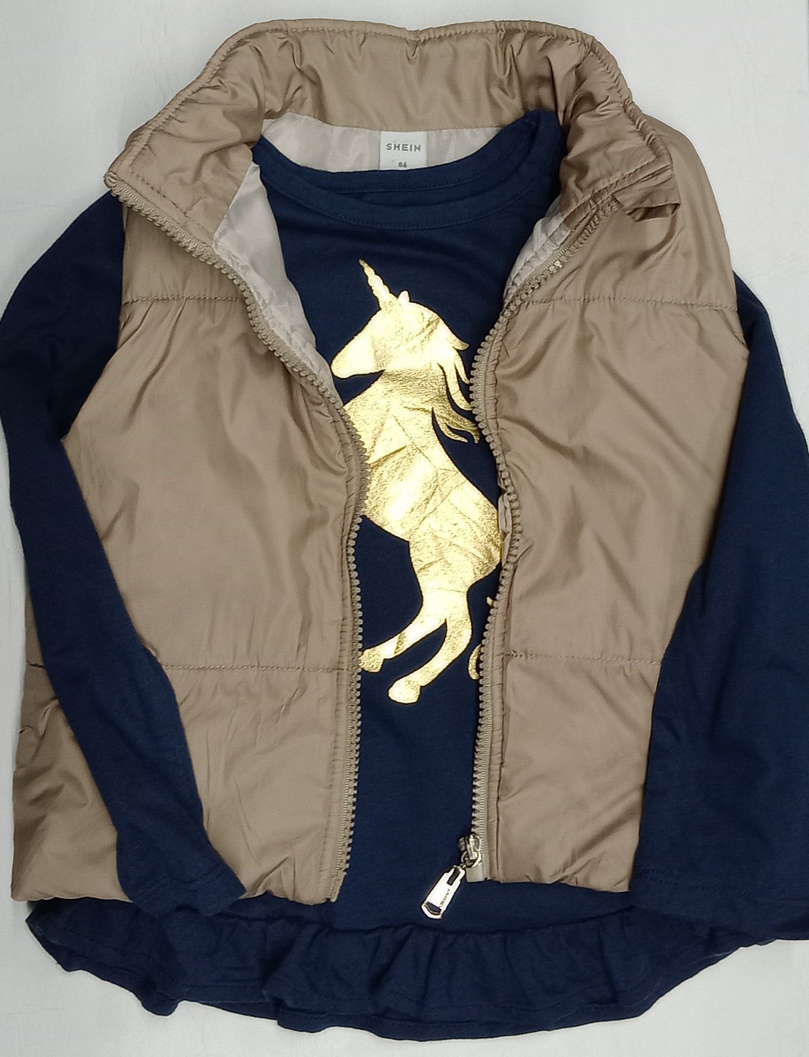Chaleco beige y remera unicornio
