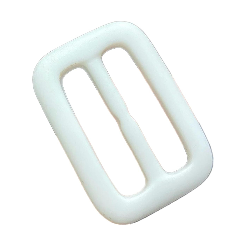 This white and black resin buckle is commonly used as an adjuster for backpack straps or belts.