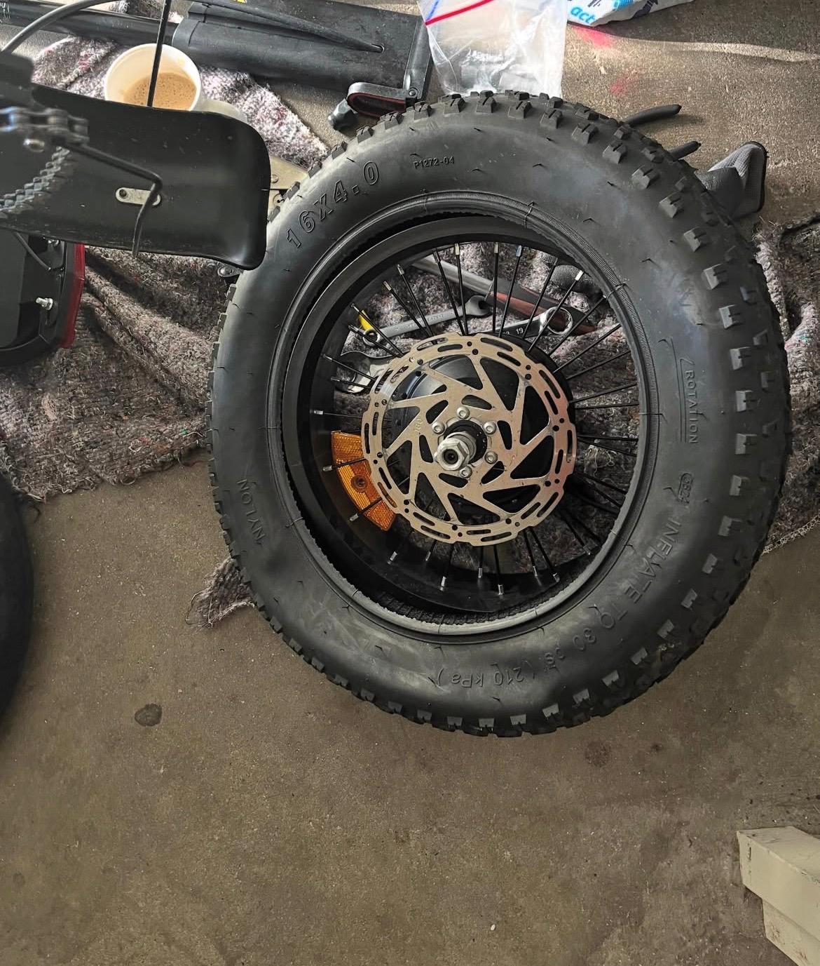 Mini fat bike repairing a flat rear wheel and mounting new tires on the rear wheel